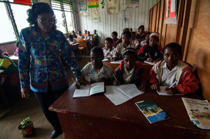 modul ajar dengan AI untuk guru: guru Indonesia memeriksa pekerjaan siswa di kelas